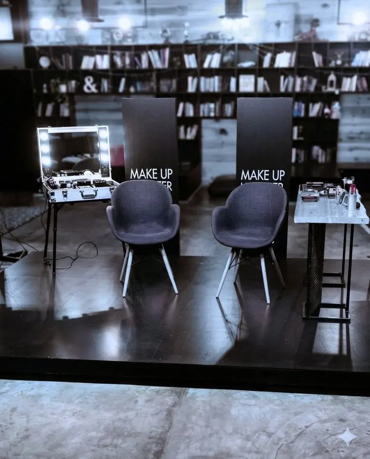 A masterclass stage with two chairs and a lit make-up station